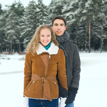 Outdoor happy couple in love posing in cold winter weatherの写真素材