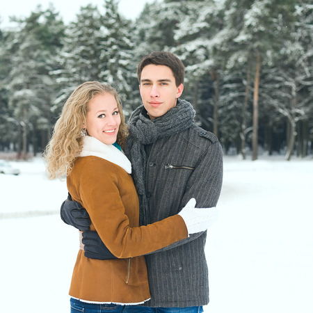 Outdoor happy couple in love posing in cold winter weatherの写真素材