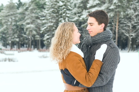 Outdoor happy couple in love posing in cold winter weatherの写真素材