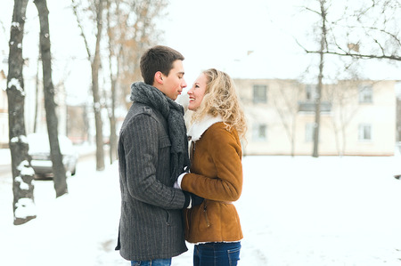 Outdoor happy couple in love posing in cold winter weatherの写真素材