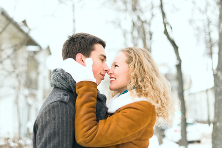 Outdoor happy couple in love posing in cold winter weatherの写真素材