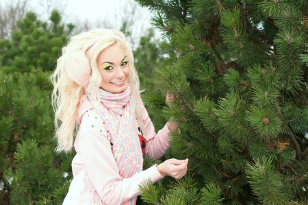 Blonde in a spruce forest in pink sweaterの写真素材