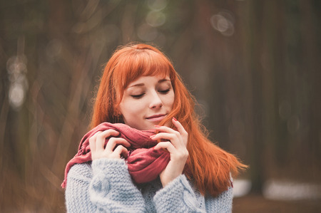 Hipster. Photo redheaded girl with a scarf. Forest.の写真素材