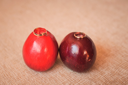 Two gold wedding rings on red Big Applesの写真素材