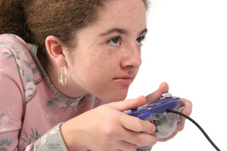 A teenaged girl holding a game controller, with an intense look of concentration.  Isolated.