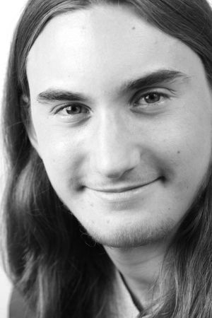 A black & white closeup of a handsome, friendly teenaged boy.