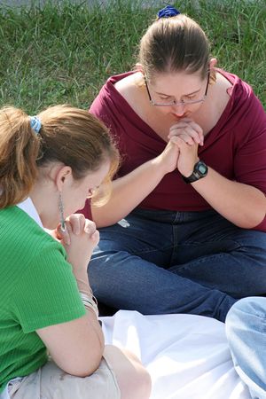 A closeup of two teen girls in prayer.の写真素材