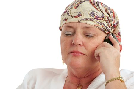 A woman, bald from chemotherapy, having a serious cell phone conversation.の写真素材
