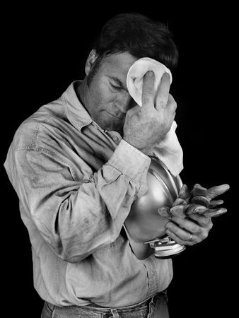 A tired coal miner wiping coal dust from his brow after a long day of work.  Black & White`の写真素材