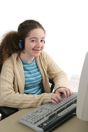 A teen girl doing her homework online and listening to headphones.の写真素材