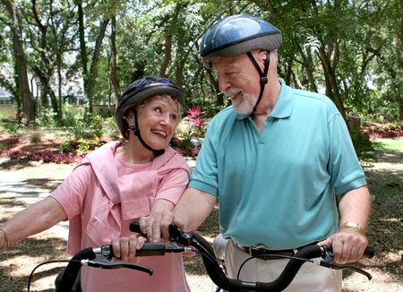 A happy senior couple staying fit by bicycling together.の写真素材