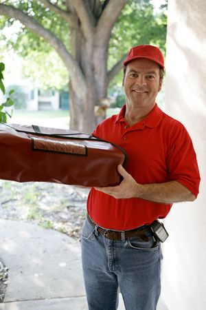 A handsome delivery man holding an insulated pizza delivery bag.の写真素材