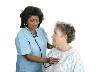 A worried patient with a doctor listening to her chest.  Isolated with focus on the patient's face.の写真素材
