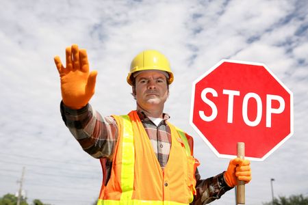 A construction worker stopping traffic, holding a stop sign.  の写真素材