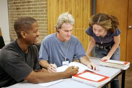 A group of diverse adult education students going over an assignment.