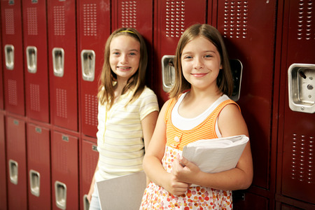 Two adolescent school girls in front of their lockers.  の写真素材