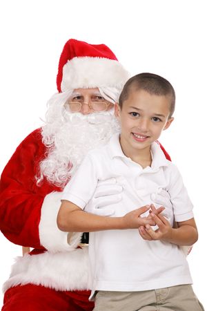 Adorable little boy sitting on Santa's Lap.  Isolated on white.の写真素材
