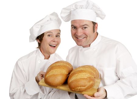 A male and female chef holding loaves of fresh baked Italian bread.  Isolated on white.  の写真素材