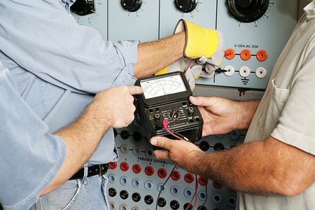 Team of actual electricians testing the voltage on an industrial power distribution center. All work...