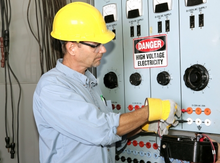 Actual electrician working on an industrial power distribution center. All work shown is being performed according to industry code and safety standards. Actual electrician working on an industrial power distribution center. All work shown is being performed according to industry code and safety standards.