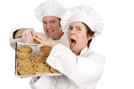 One chef upset because she caught another cook stealing her cookies.  Isolated on white.  の写真素材