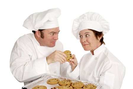 Two chefs fighting over a freshly baked chocolate chip cookie.  Isolated on white.  の写真素材