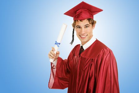 Handsome young graduate holding his diploma on a blue background with room for text.  の写真素材