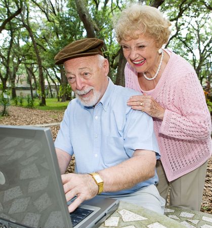 Senior couple on computer enjoying e-mail from their grandchildren. の写真素材