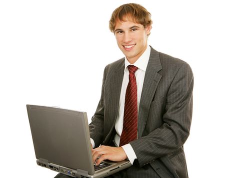 Handsome young businessman typing on his laptop.  Isolated on white.  の写真素材