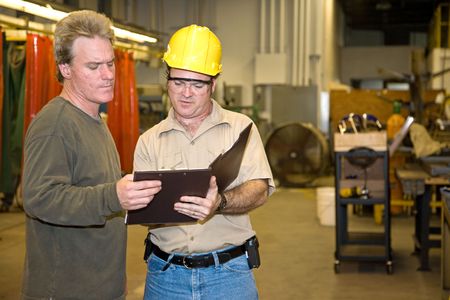 Industrial auditor discussing his inspection results with the factory owner.  