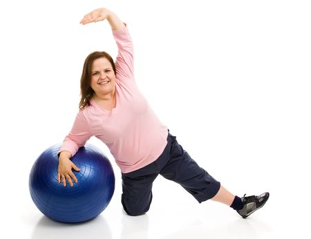 Beautiful plus sized model exercising with a pilates ball.  Full body isolated on white.  の写真素材