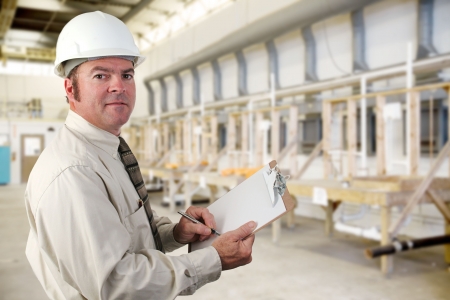 Inpector performing an audit of a plumbing factory. Inpector performing an audit of a plumbing factory.