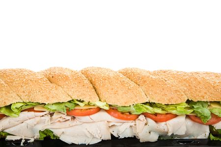 Closeup view of a giant three foot turkey submarine sandwich against a white background.の写真素材