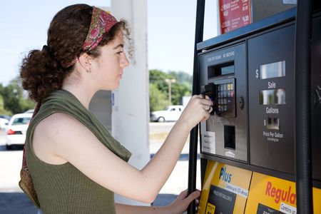 Young woman uses her credit card to pay for gasoline at the pump.  の写真素材