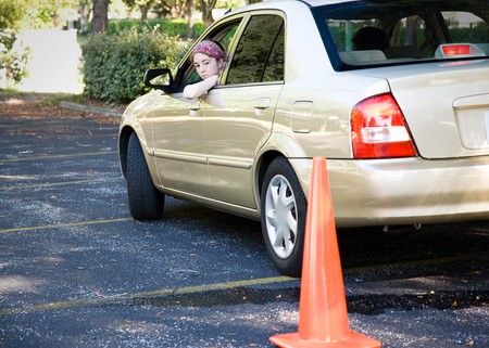 Teen driver backs up, doing the parking portion of her driving test.  の写真素材