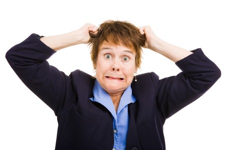 Mature business woman overwhelmed with frustration, pulling her hair.  Isolated on white.の写真素材