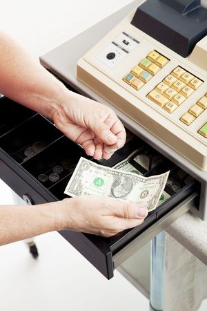 Closeup of a cashier's hands making change from a cash register.