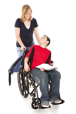 Teen girl pushing her disabled friend in his wheelchair.  Full body isolated.の写真素材