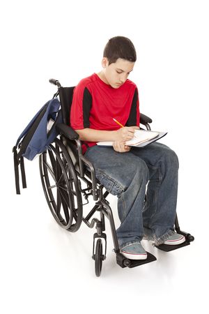 Disabled teenage boy doing homework in his wheelchair.  Full body isolated.の写真素材