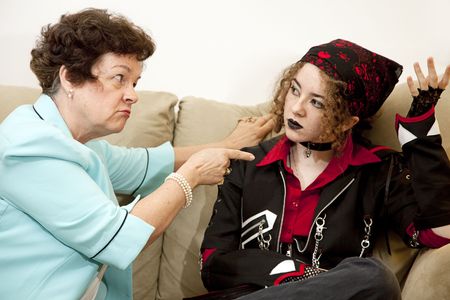 Angry mother pointing the finger at her rebellious teenage daughter.  Focus on the mom.  の写真素材