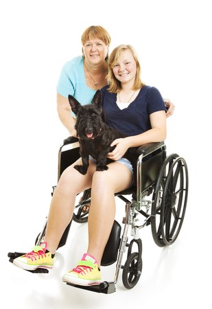 Disabled teen girl in wheelchair, posing with her mom and dog.  Full body isolated.の写真素材