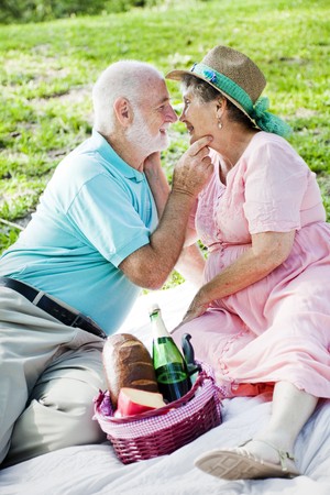 Senior couple on a picnic gets romatic.  の写真素材