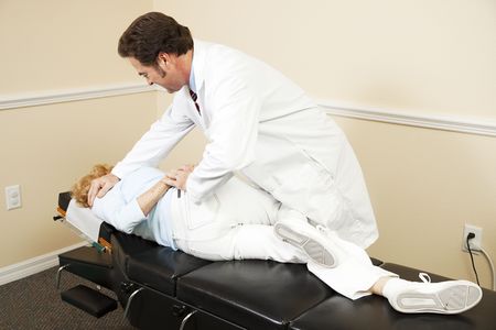Chiropractor adjusting a patient in his office.  の写真素材