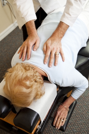 Closeup of a chiropractor's hands as he adjusts a senior patien in his office.  の写真素材