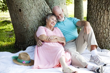 Beautiful senior couple relaxes in the shade at the park.  の写真素材