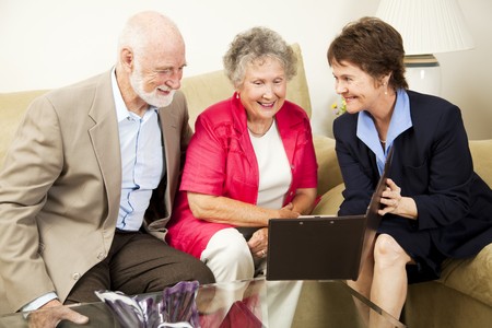 Saleswoman meets with senior couple in their home.  Could be real estate, life insurance, etc.  の写真素材
