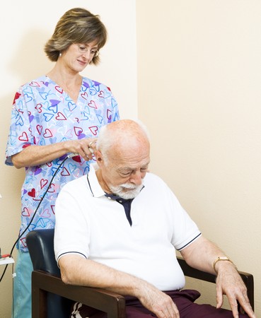 Senior man getting ultrasound therapy on his neck, at the chiropractors office.  の写真素材
