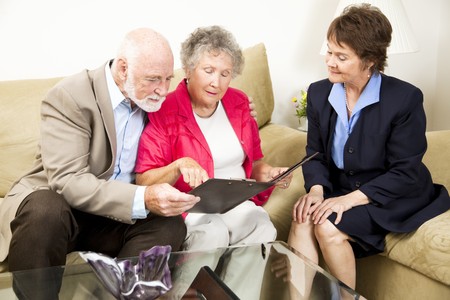 Sales woman looks on as a senior couple considers her product information. の写真素材
