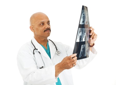 Handsome african-american doctor examines a patient's x-rays.  Isolated on white.の写真素材