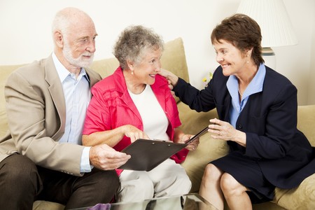Sales woman making an aggressive pitch to a senior couple.  The husband is skeptical.の写真素材